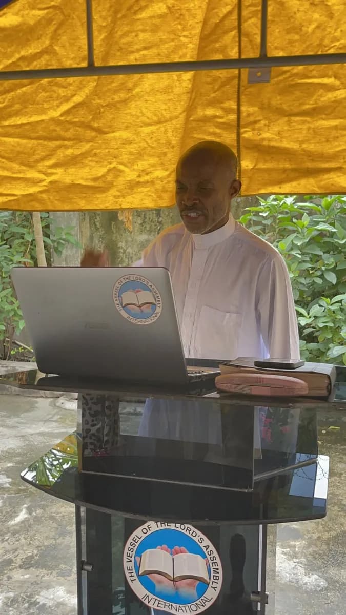 A minister teaching at the fellowship's pulpit, with the church emblem on the front
